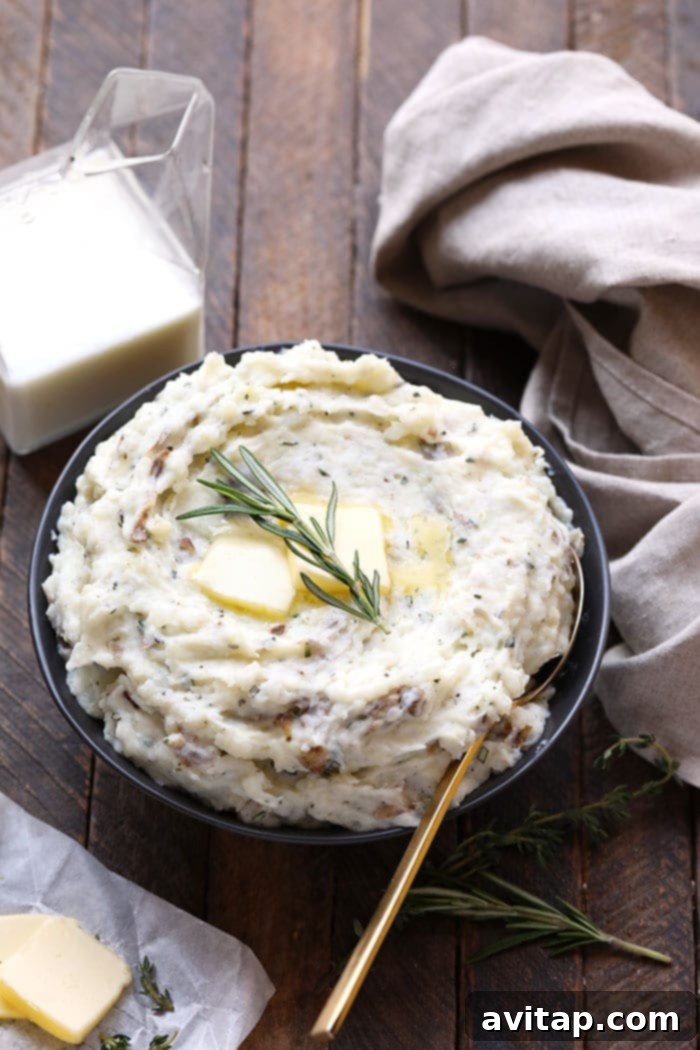 Healthy Mashed Potato Perfection 7 A bowl of homemade healthy mashed potatoes, elegantly garnished with a sprig of rosemary, showcasing its inviting texture.
