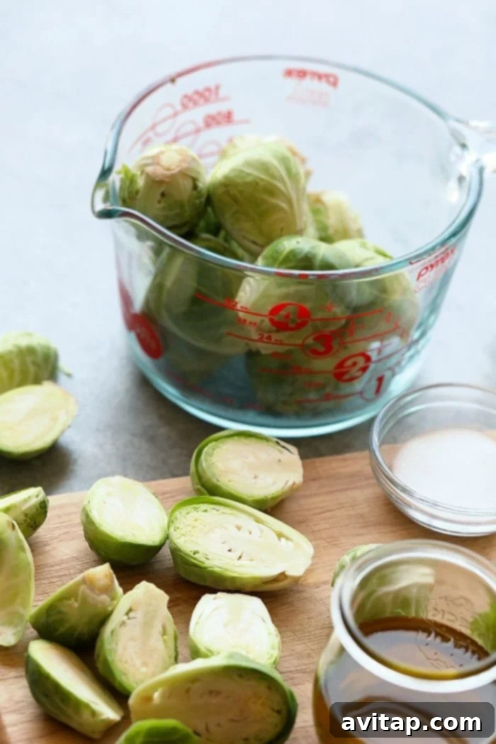Chopped fresh Brussels sprouts on a cutting board, ready for grilling.