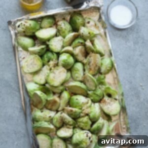 Tin foil boat filled with seasoned Brussels sprouts, ready for the grill.