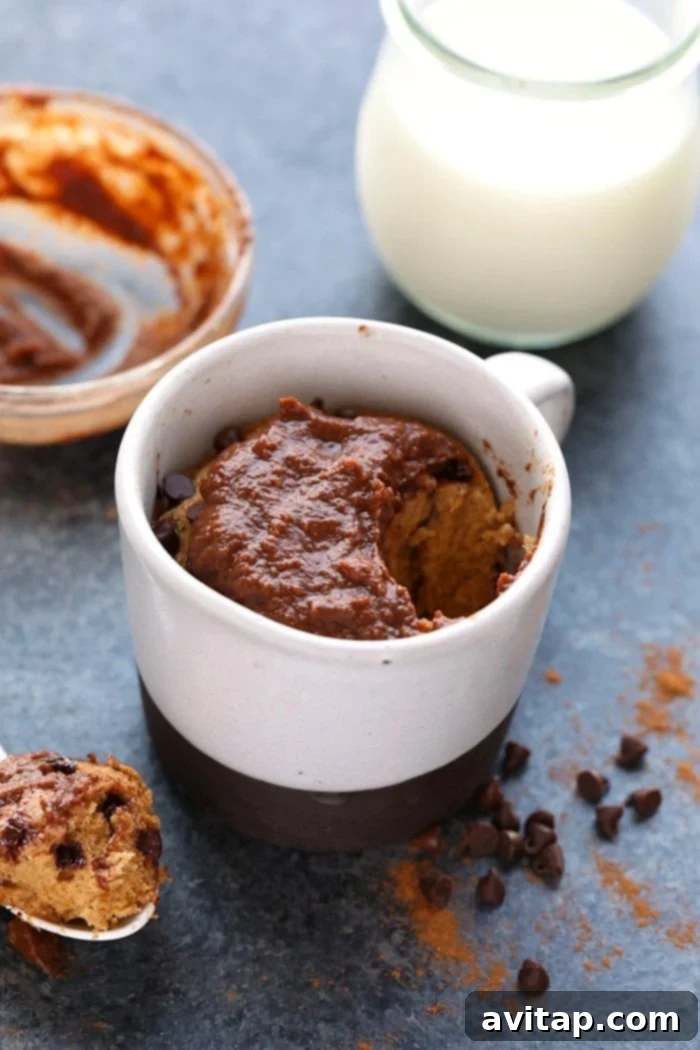 A final shot of a healthy pumpkin mug cake, garnished with chocolate chips and frosting, ready to be enjoyed.