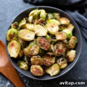 Crispy Parmesan Brussels Sprouts 5 Roasted Brussels sprouts topped with parmesan in a bowl.