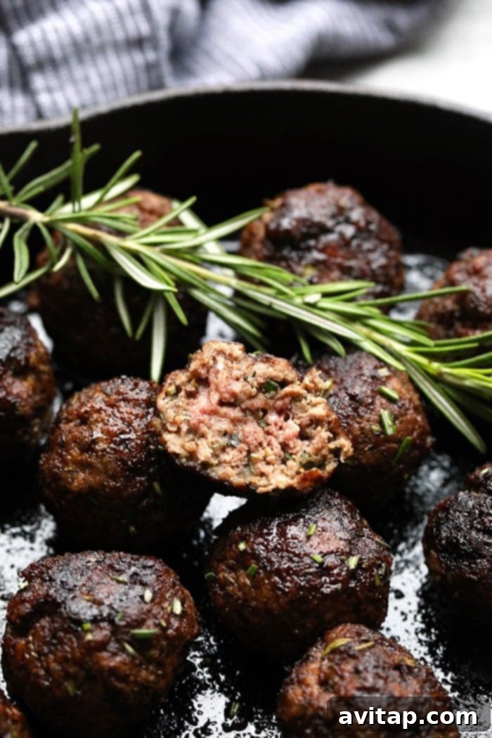 Delicious Rosemary Thyme Balsamic Meatballs glistening in a rustic cast iron pan, ready to be served as an appetizer or main dish.