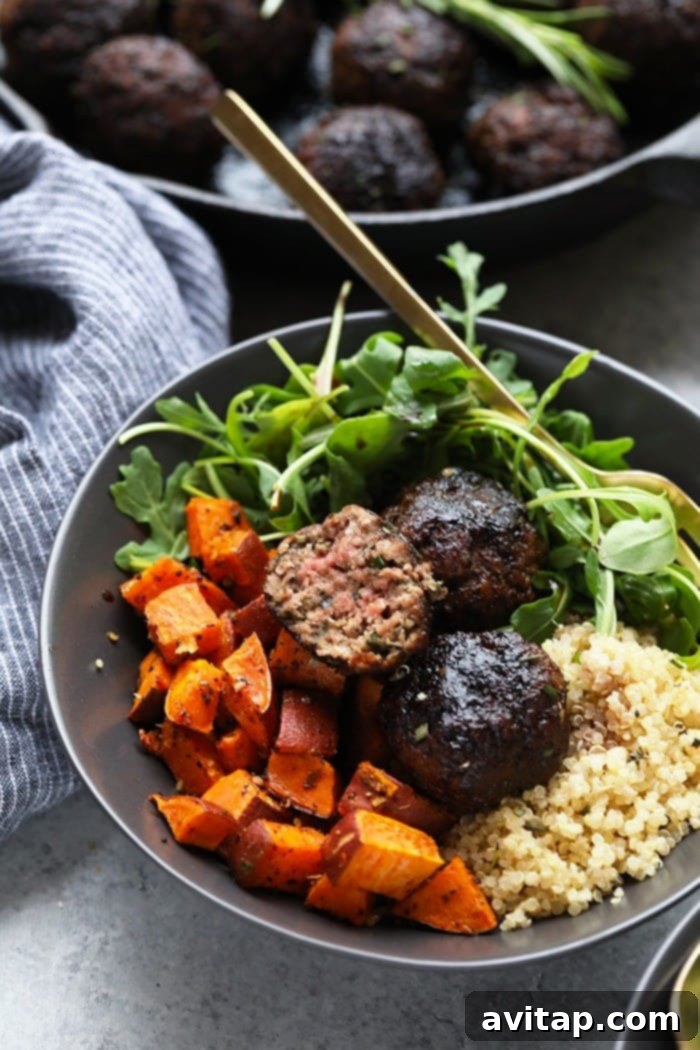 Plated Rosemary Thyme Balsamic Meatballs served with quinoa, roasted sweet potatoes, and fresh arugula for a complete meal.
