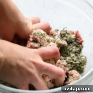 A person effortlessly combines herbs and meat in a bowl to create a delectable dish.