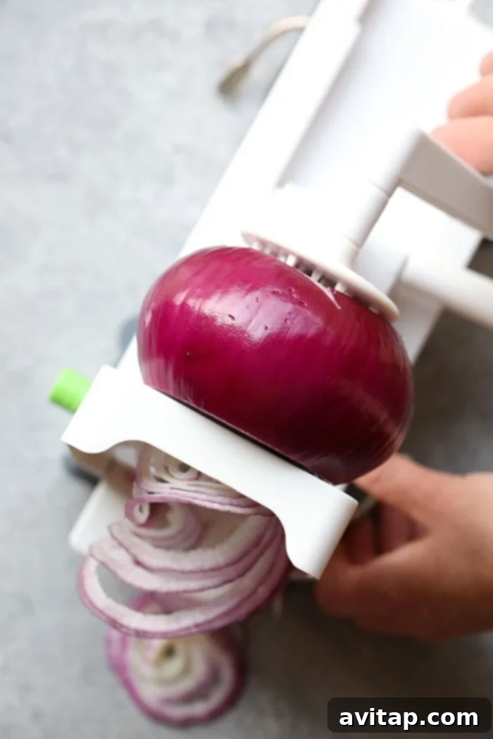Oven Caramelized Onions 4 Sliced red onions tossed with olive oil, salt, and pepper on a baking sheet before roasting