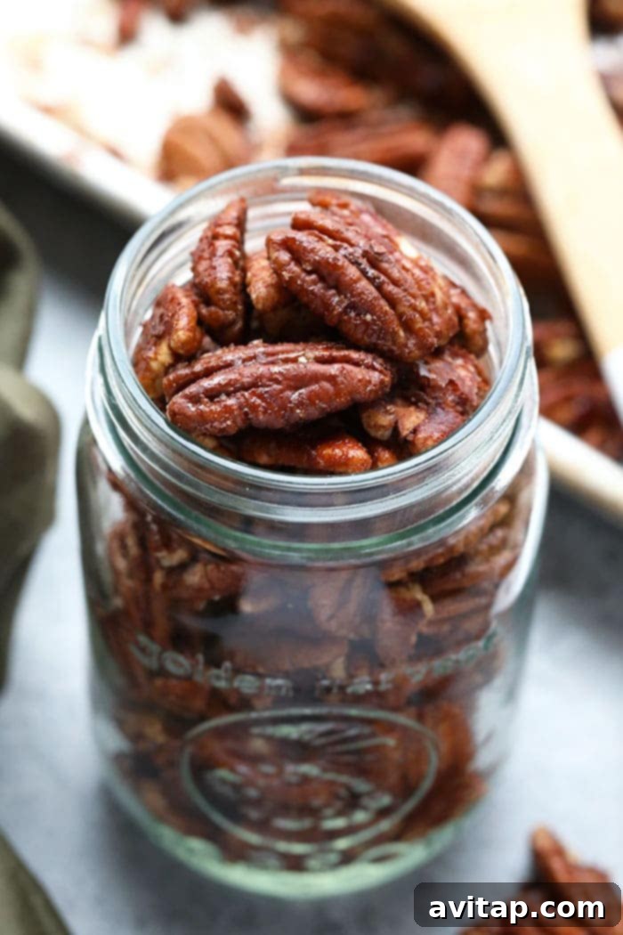 A glass jar elegantly filled with maple roasted pecans, sealed for freshness.
