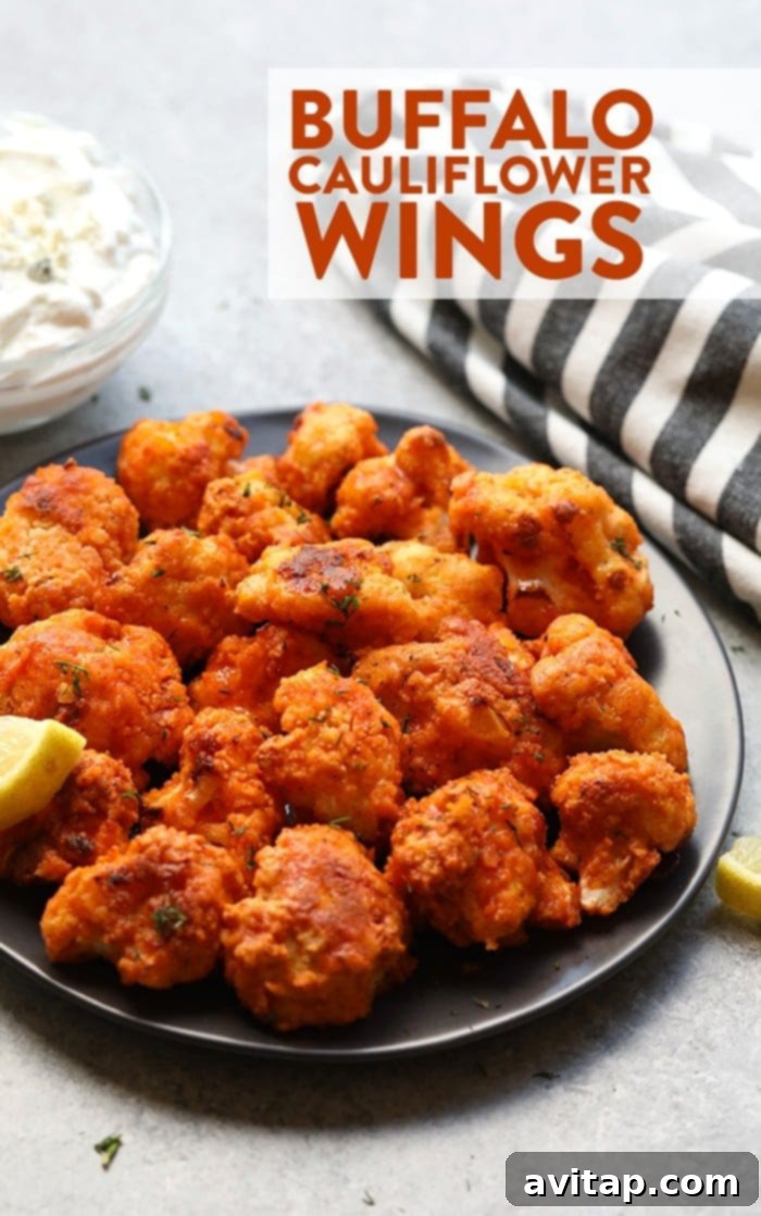Crispy buffalo cauliflower wings served on a plate with dip.