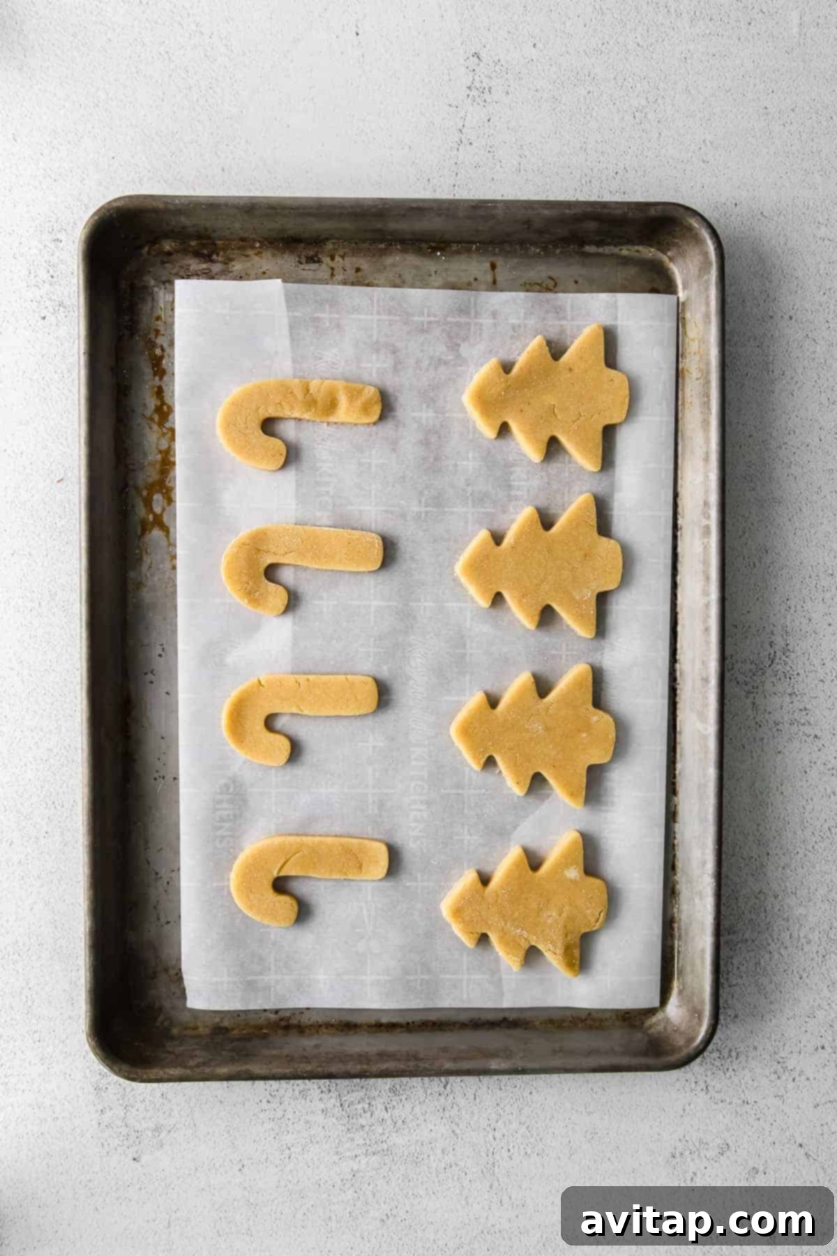 Freshly baked almond flour sugar cookies cooling on a baking sheet, ready for decorating.