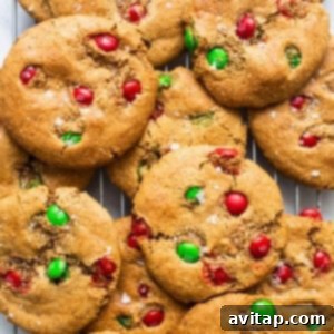 Freshly baked flourless M&m cookies cooling on a wire rack.
