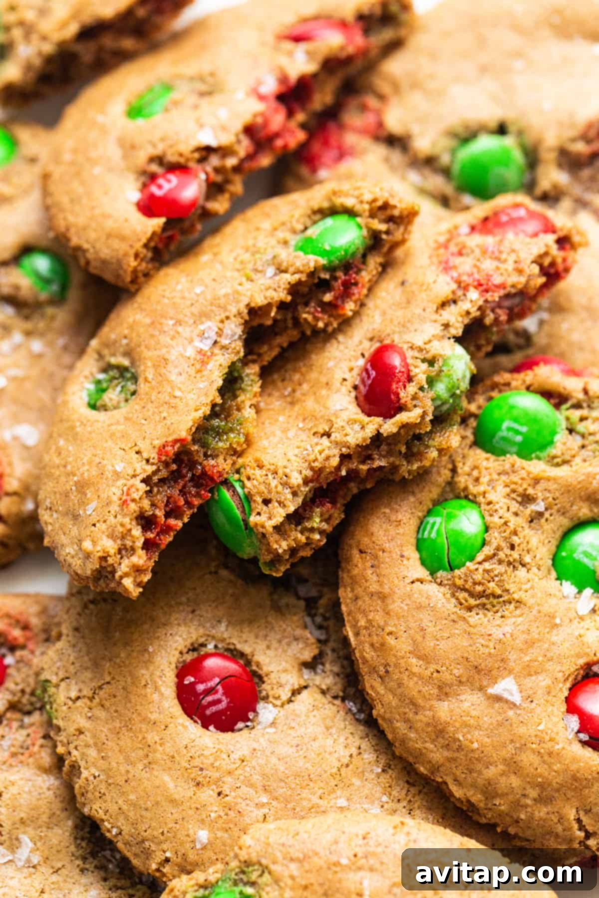 A beautiful pile of freshly baked M&M cookies, topped with extra M&Ms and a sprinkle of coarse sea salt.