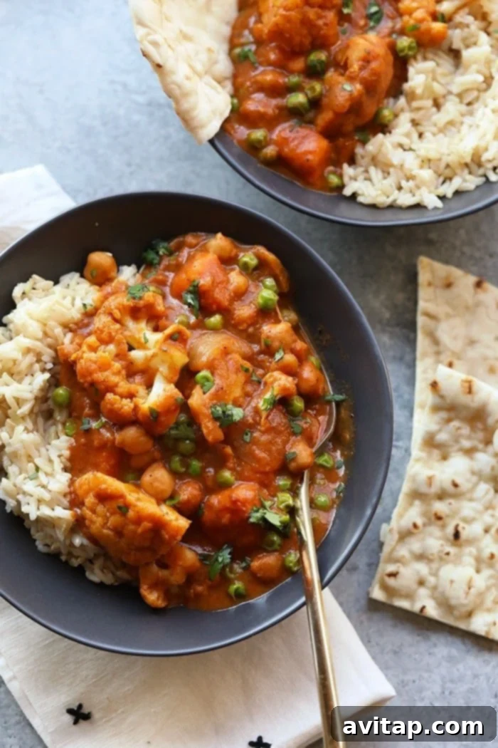Hearty Cauliflower Tikka Masala, ideal for meal prep, packed with veggies and spices. Vibrant Cauliflower Tikka Masala served in a bowl, accompanied by fluffy naan bread.