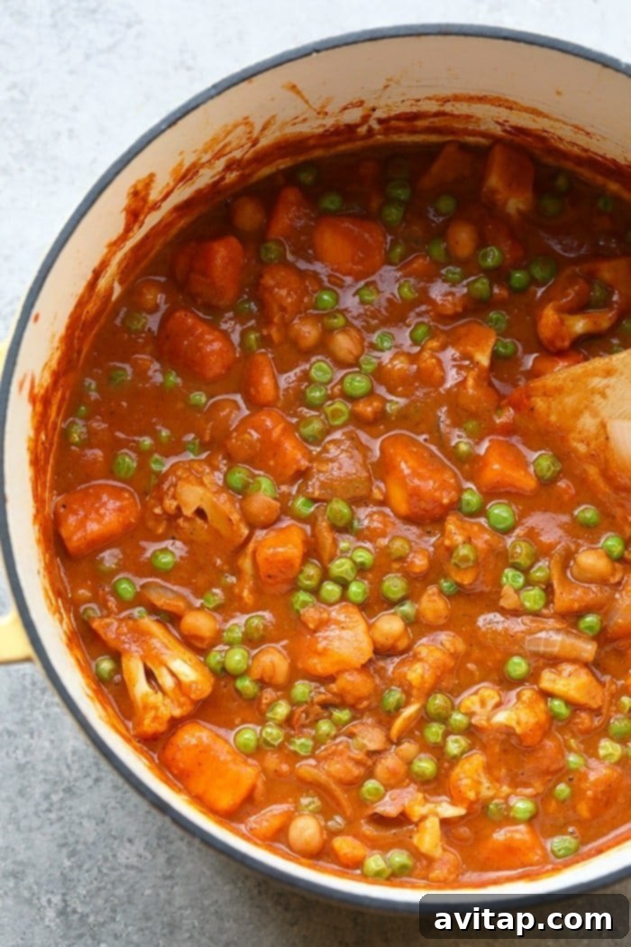 A comforting pot of Cauliflower Tikka Masala, ready for serving. Cauliflower Tikka Masala simmering in a rustic dutch oven, exuding rich aromas.