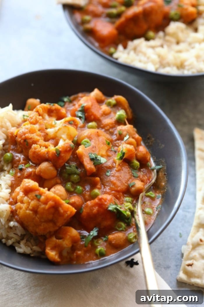Delicious Cauliflower Tikka Masala ready to be enjoyed. A serving of Cauliflower Tikka Masala in a bowl, garnished with fresh herbs.
