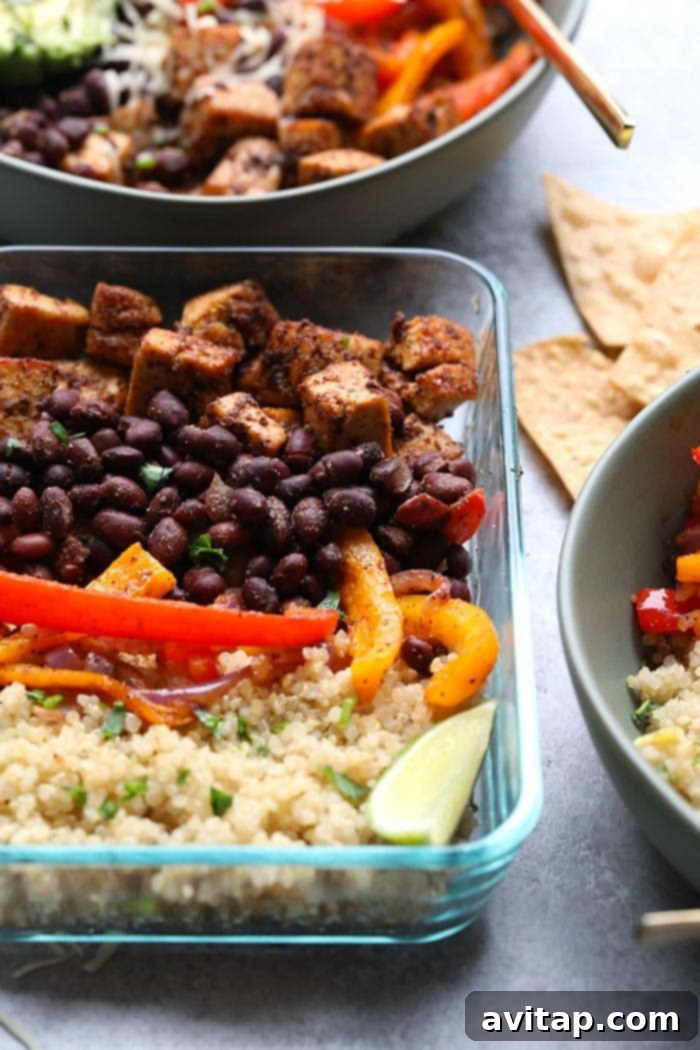 A close-up of a beautifully assembled Tofu Quinoa Burrito Bowl, topped with fresh avocado and cilantro, highlighting its vibrant and healthy appeal.