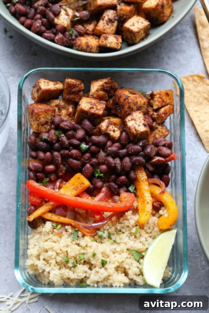 A close-up shot highlighting the beautifully textured and seasoned roasted tofu alongside colorful bell peppers, a key component of the Tofu Quinoa Burrito Bowls.