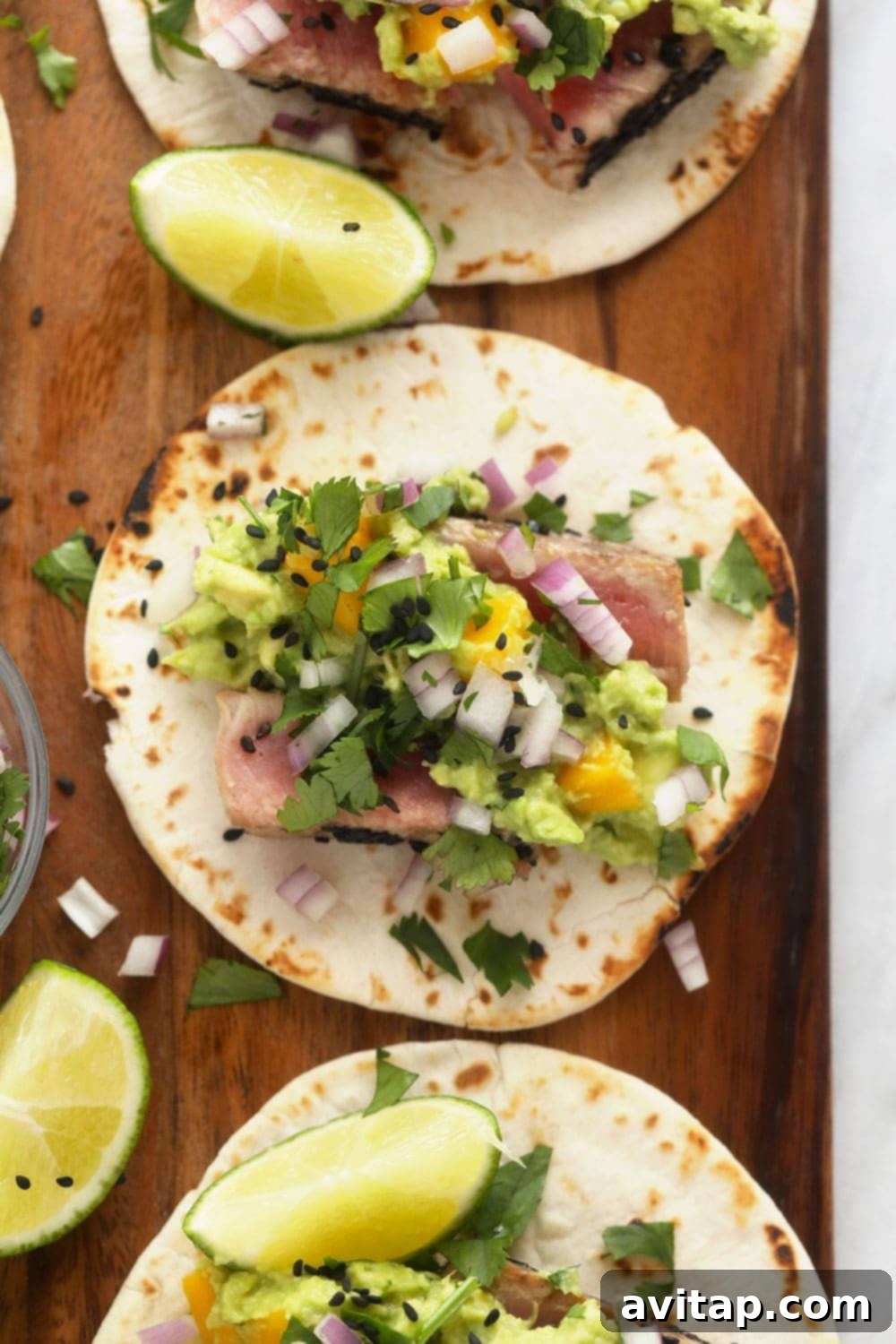 Gorgeous Ahi Tuna Tacos that are perfectly seared with sesame seeds and served with a citrus mango guacamole! ahi tuna tacos on cutting board