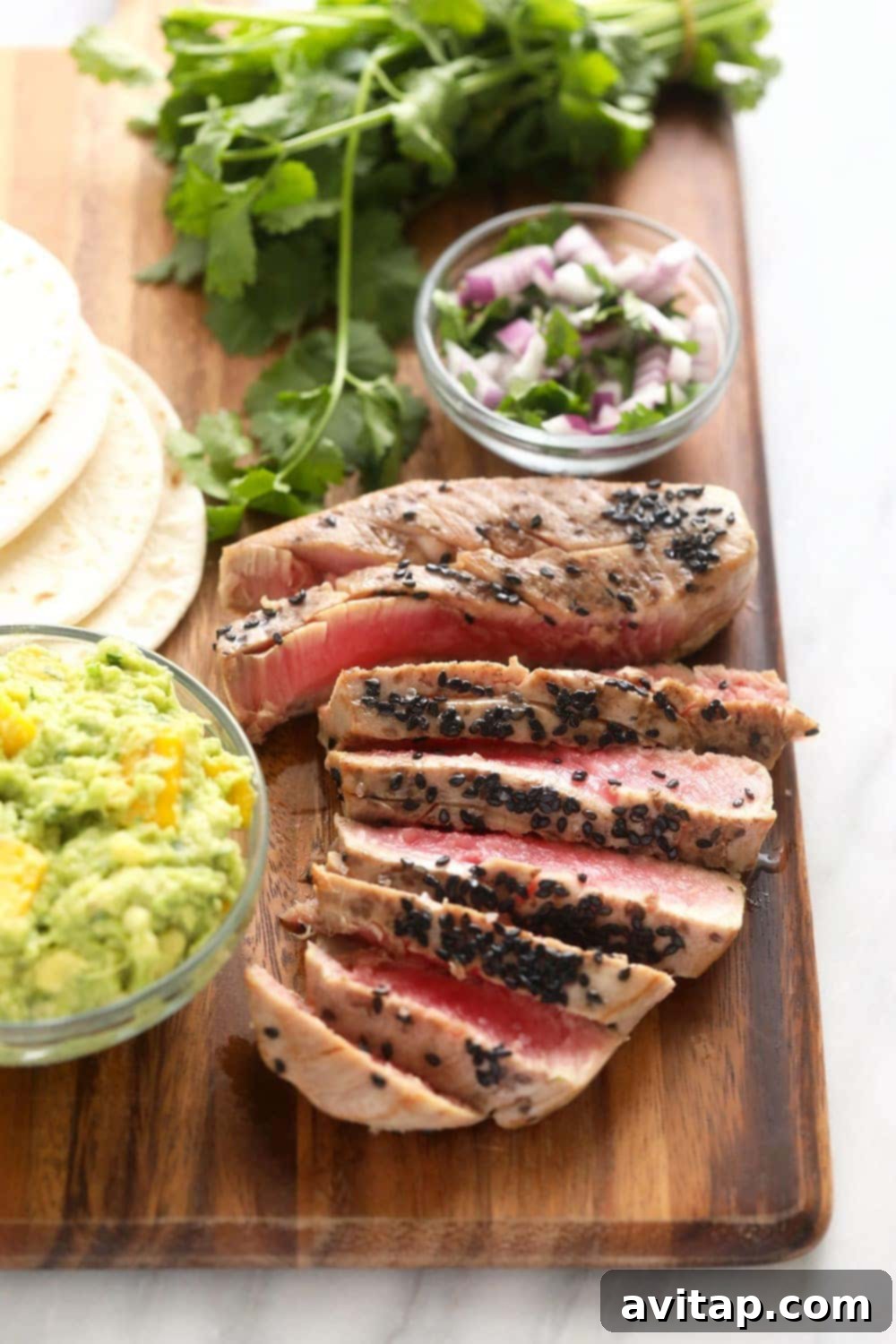 Gorgeous Ahi Tuna Tacos that are perfectly seared with sesame seeds and served with a citrus mango guacamole! sliced seared ahi tuna