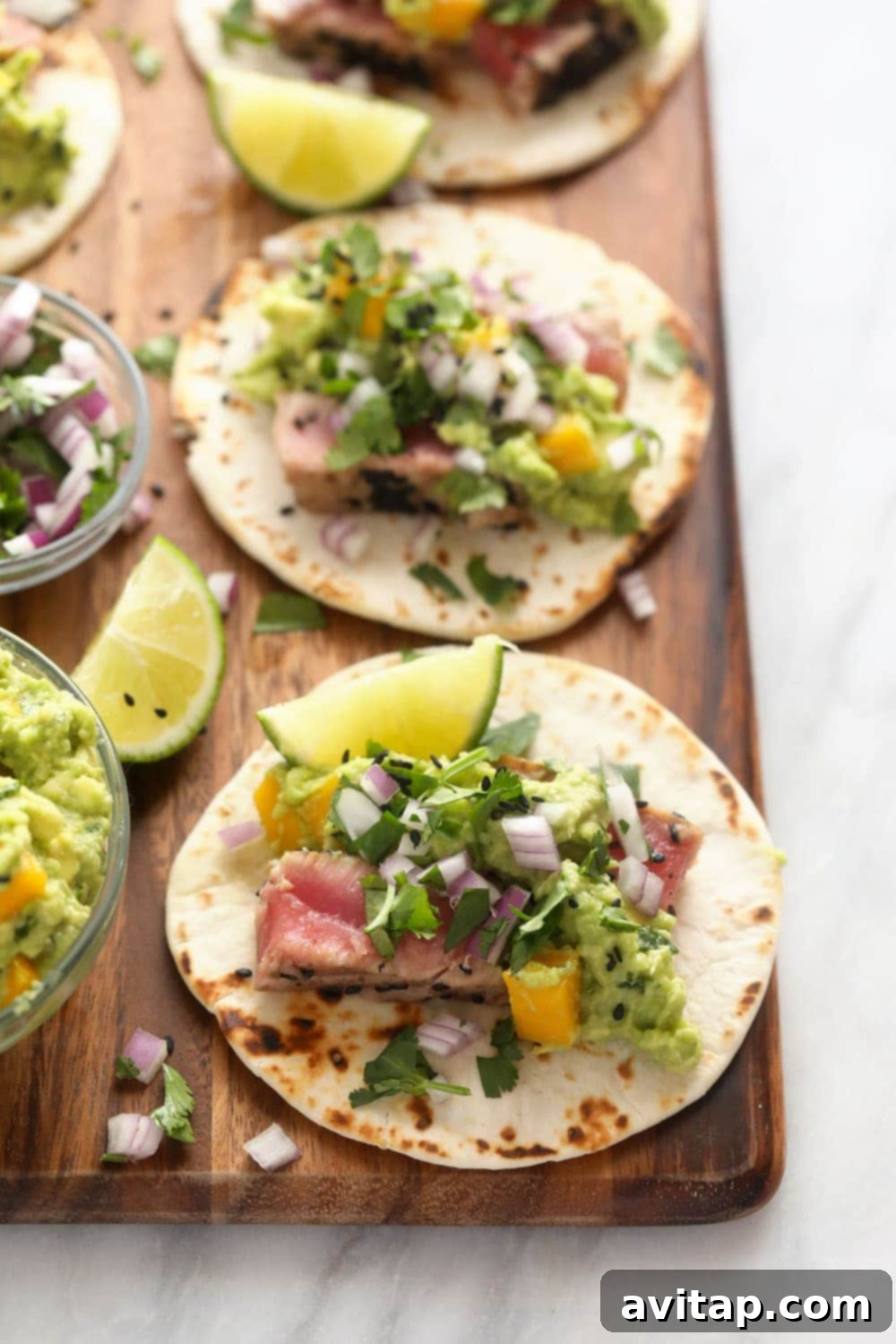 Gorgeous Ahi Tuna Tacos that are perfectly seared with sesame seeds and served with a citrus mango guacamole! ahi tuna tacos on cutting board