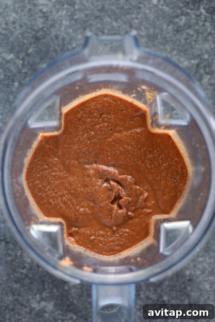 Pureed Black Bean Soup for Creamy Texture The creamy, pureed black bean soup in an immersion blender container, showcasing its smooth consistency before being returned to the slow cooker.