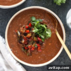 Slow Cooker Black Bean Chili 2 Two bowls of garnished black bean soup elegantly placed on a rustic table, ready to be served.
