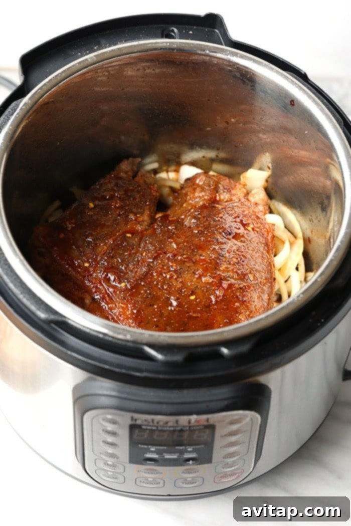 The Instant Pot containing tender Korean beef in its flavorful sauce, ready to be shredded and served.