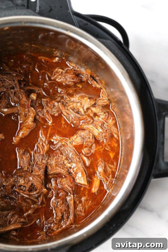A beautifully assembled Instant Pot Korean Beef Bowl, showcasing the shredded beef, rice, bell peppers, and fresh garnishes.