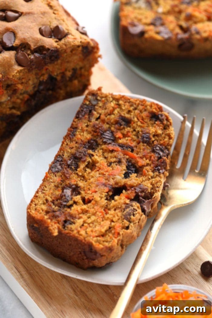 A large slice of homemade healthy carrot cake loaf, showcasing its rich texture and delicious appeal.