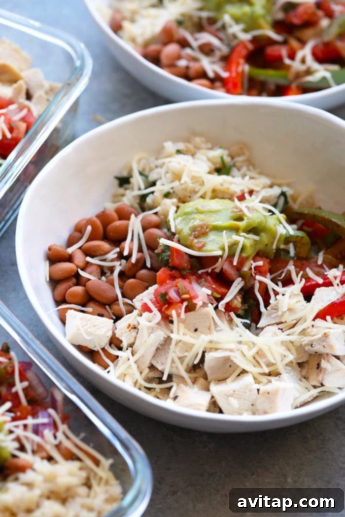 Stacked meal prep containers filled with homemade chicken burrito bowls