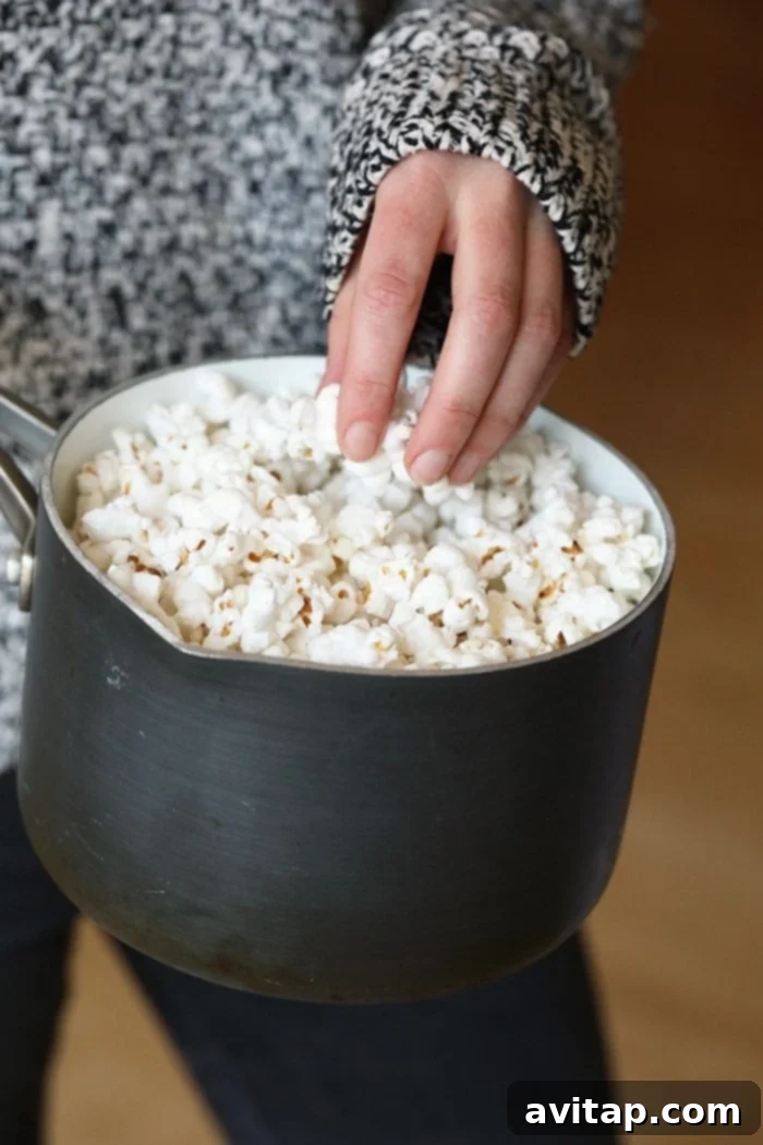 Freshly popped stovetop popcorn filling a large pot, ready for serving
