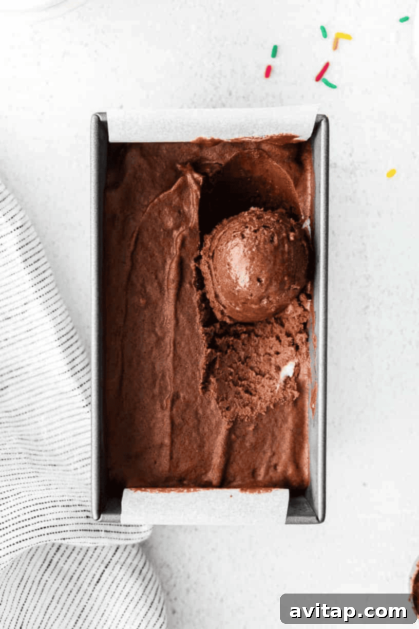Guilt-Free Chocolate Protein Bliss 5 A charming close-up of chocolate protein ice cream presented in a small, rustic wooden box, adorned with colorful sprinkles, highlighting its delightful texture.