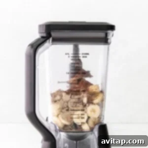A blender filled with bananas and other ingredients ready to be processed into ice cream.