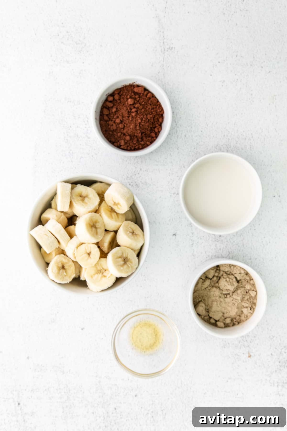 Guilt-Free Chocolate Protein Bliss 3 A beautiful flat lay photograph showcasing all six essential ingredients for chocolate protein ice cream arranged neatly in small, elegant bowls.