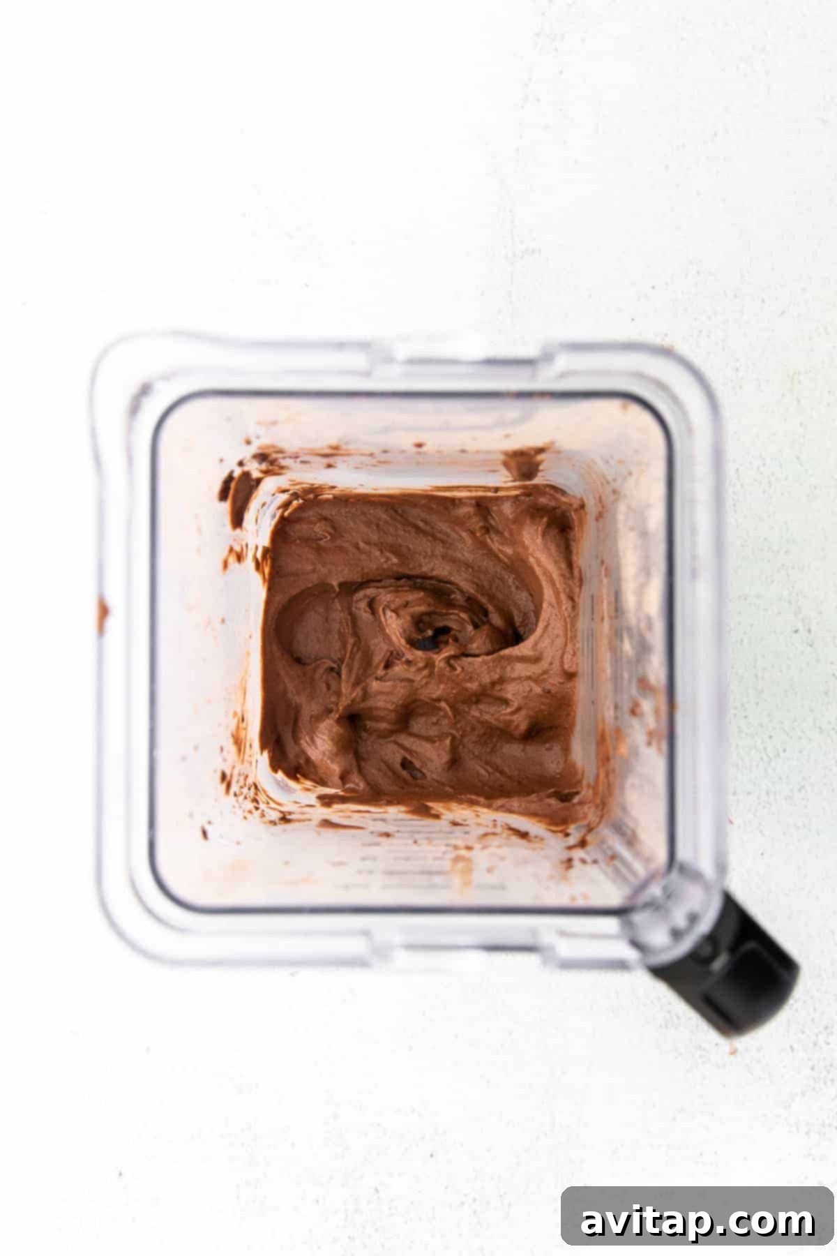 Guilt-Free Chocolate Protein Bliss 4 A high-speed blender actively processing ingredients for chocolate protein ice cream, illustrating the key step of achieving a smooth, creamy consistency.