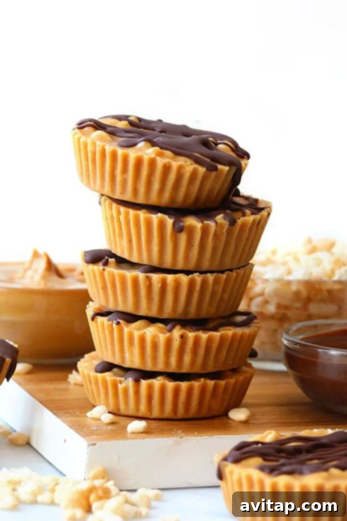 A stack of peanut butter cups on a cutting board, garnished with a sprinkle of sea salt and a light chocolate drizzle. They are stacked neatly, highlighting their tempting appearance.