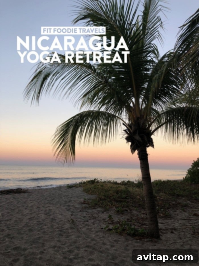 A woman standing on a beach with a surfboard, looking out at the ocean, embodying adventure and freedom in Nicaragua.