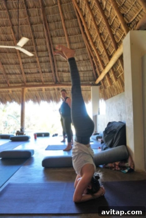 A person performing a graceful headstand yoga pose on a picturesque beach in Nicaragua, symbolizing peace and strength.
