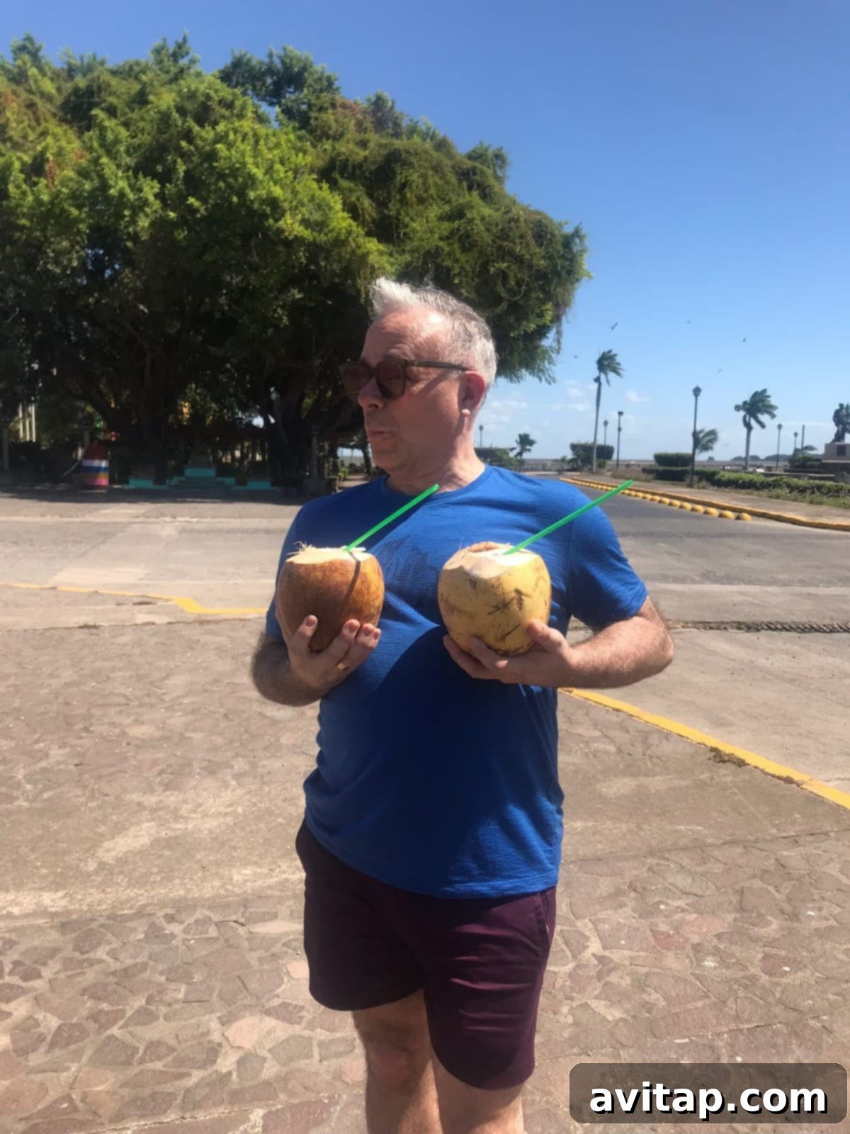 A local man carrying coconuts on his shoulder, captured in a candid street scene in Granada, Nicaragua.
