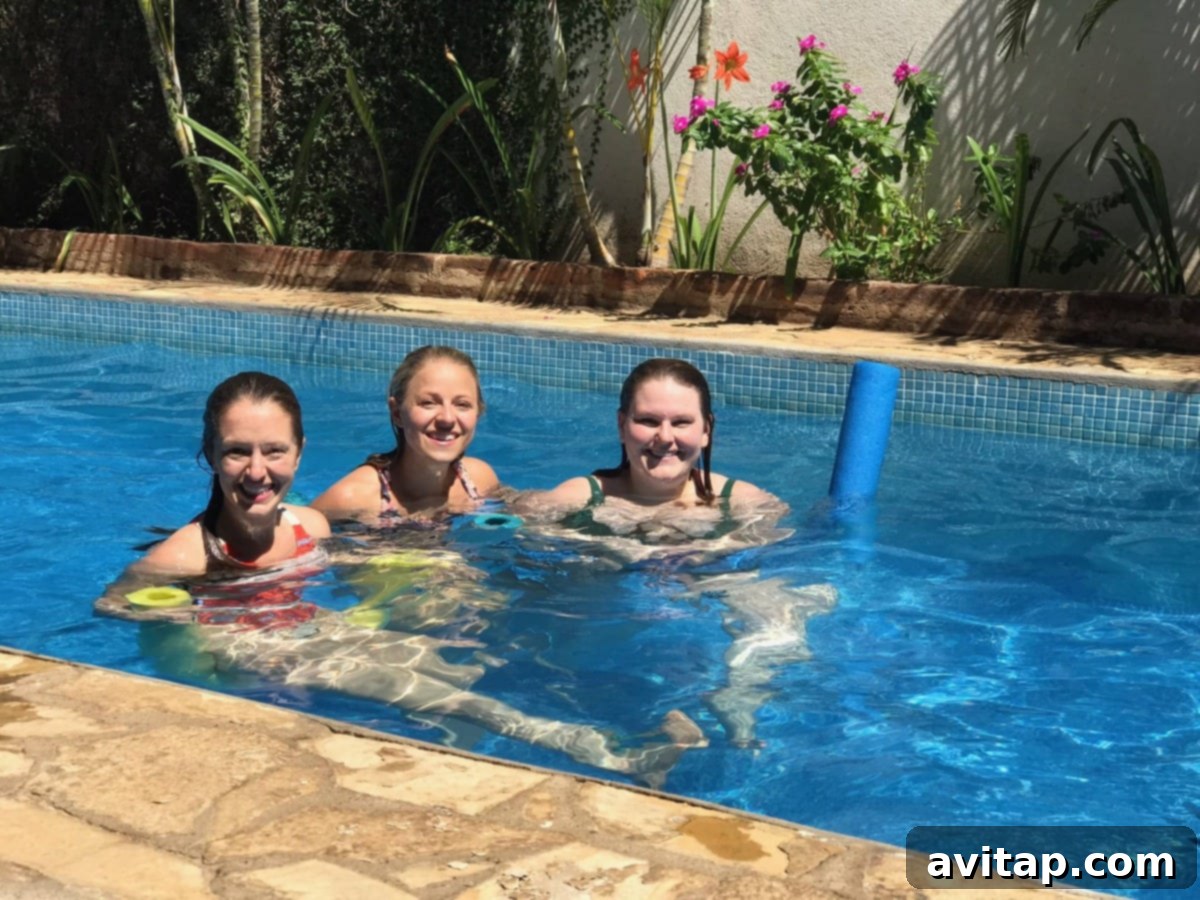Three women relaxing by a beautiful swimming pool at Hotel con Corazon, a boutique hotel in Granada, Nicaragua.