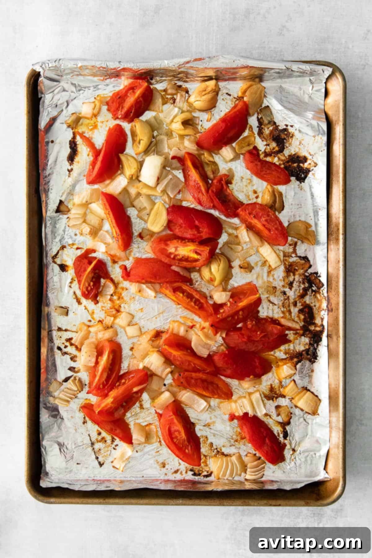 roasted tomatoes, onions, and garlic on a baking sheet
