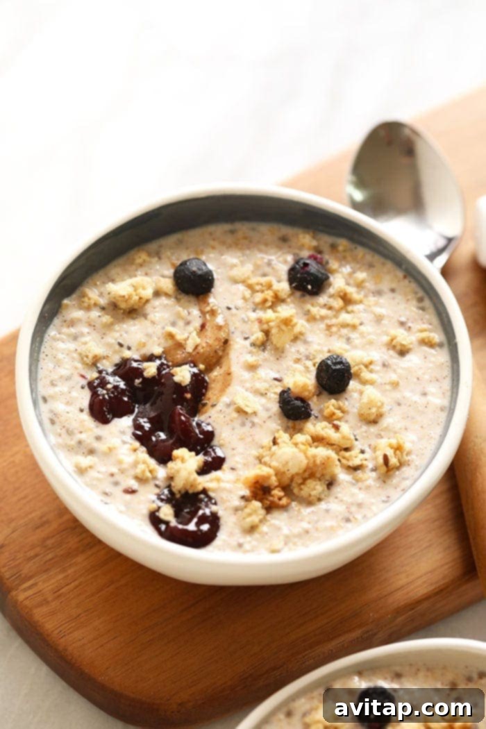 A bowl of creamy steel-cut oats topped with fresh berries and seeds.