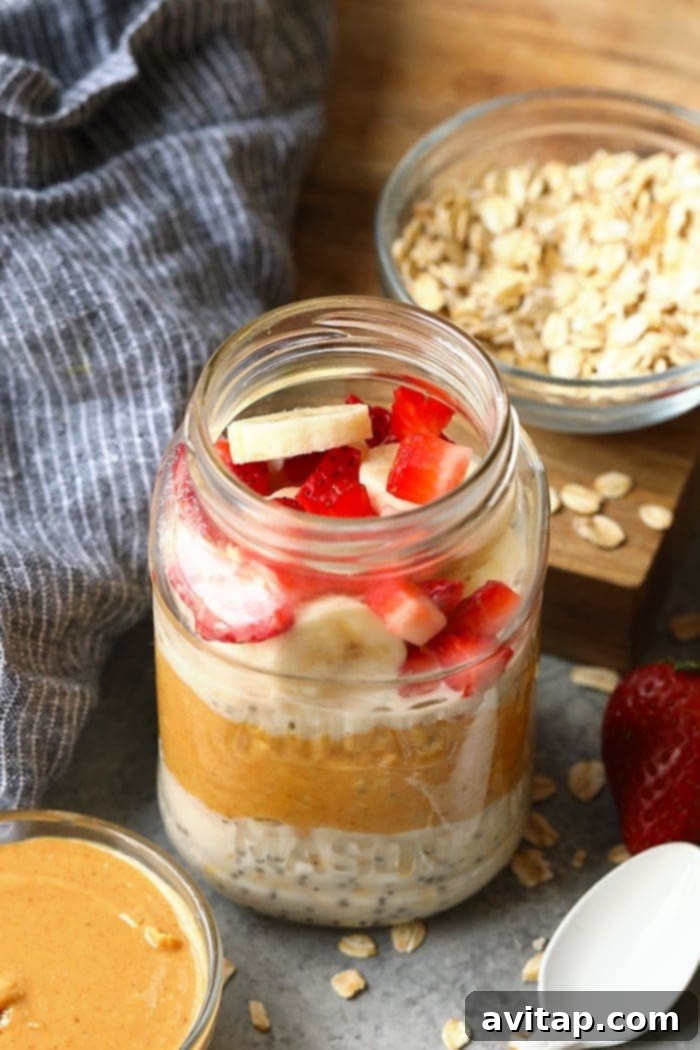 Vegan overnight oats in a glass jar, garnished with fresh berries and mint.