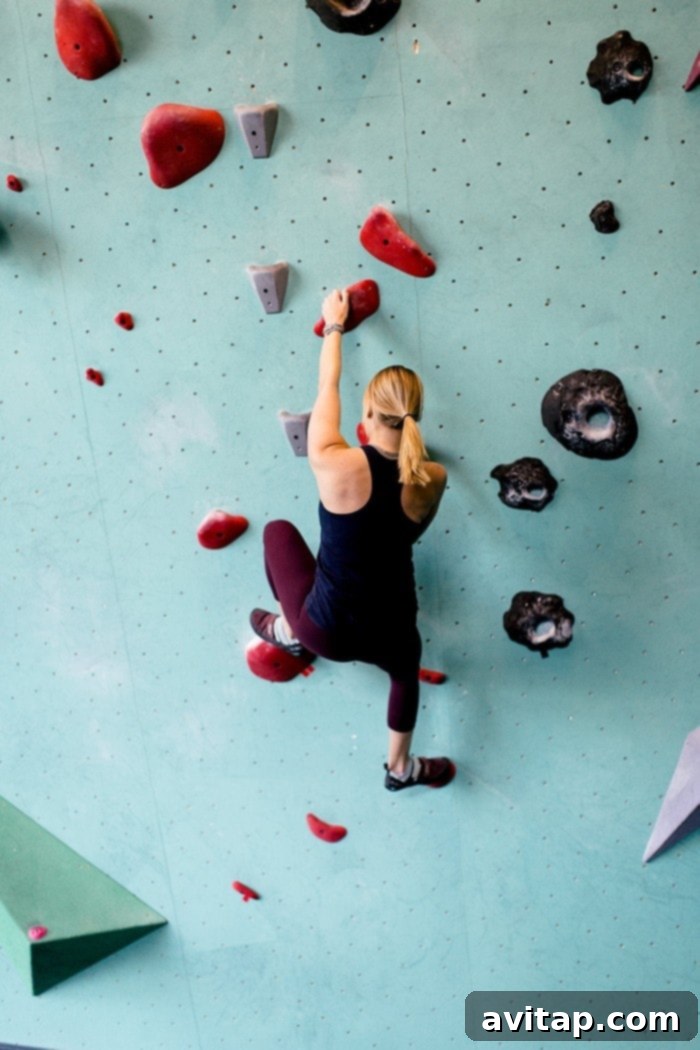 A climber gracefully navigating a bouldering wall at the Minneapolis Bouldering Project during the Bloodys and Bouldering event.