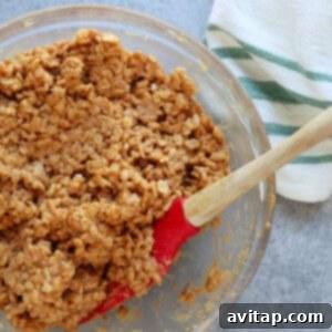 scotcheroos mixture in bowl, showcasing the peanut butter and honey combined with crispies.