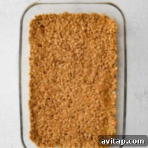 rice crispies in pan, forming the base layer for the scotcheroos.