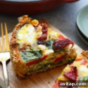 A slice of sweet potato crust quiche on a cutting board, highlighting the healthy and vibrant ingredients.