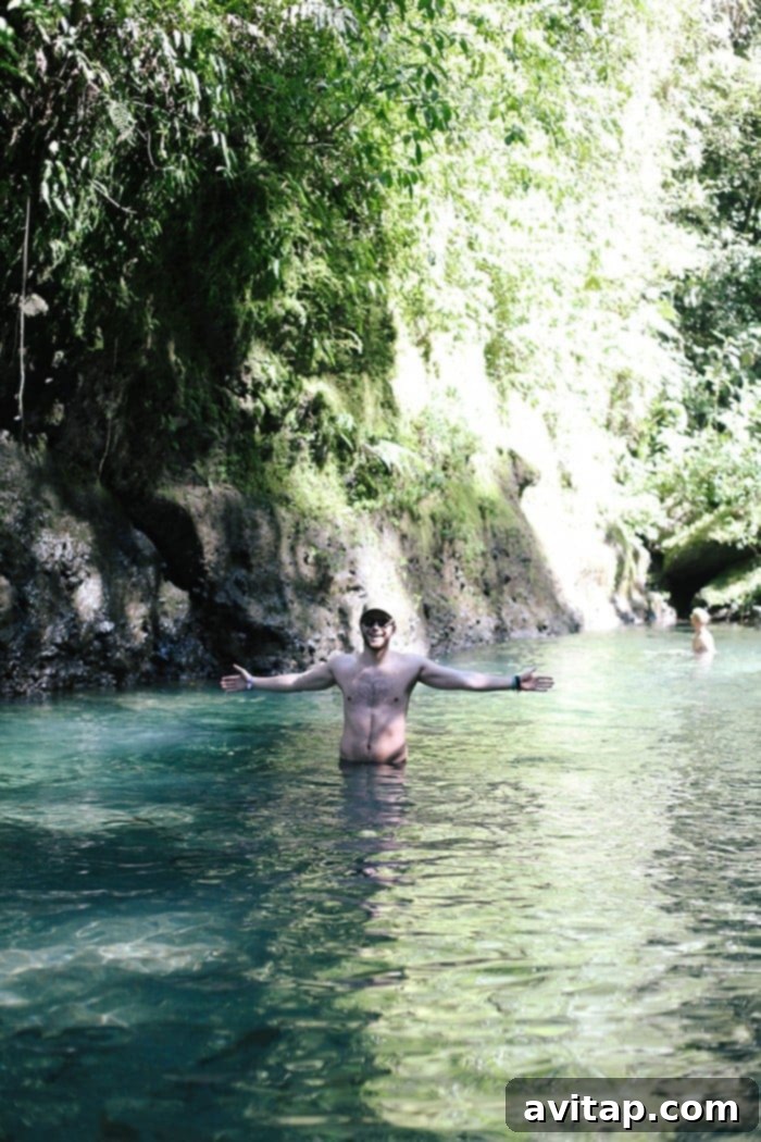 Man enjoying a swim in the refreshing waters of La Fortuna Waterfall, Costa Rica