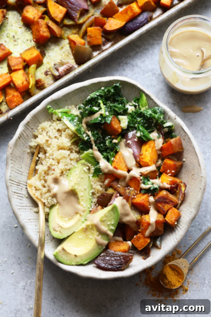 A beautifully arranged sweet potato buddha bowl featuring roasted sweet potatoes, fresh greens, and a drizzle of tahini.