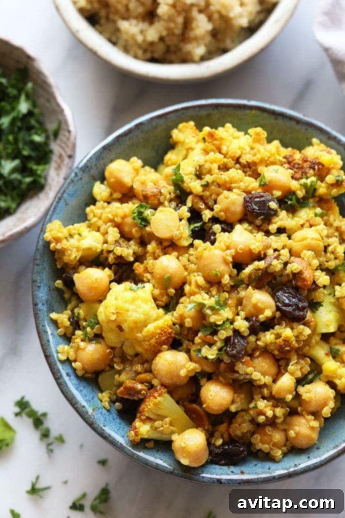 A beautifully presented single serving of Golden Roasted Cauliflower and Quinoa Salad in a small bowl.