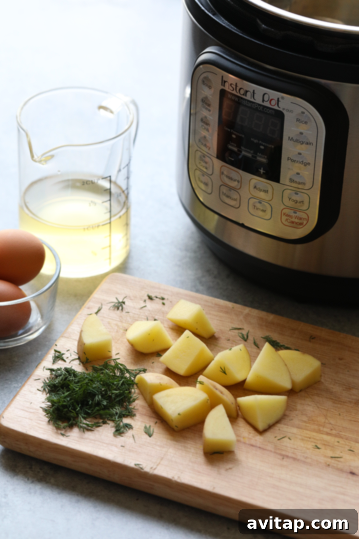 Fresh ingredients for a classic potato salad, including cubed potatoes, eggs, bunches of dill, and a jar of pickles, neatly arranged on a wooden cutting board.