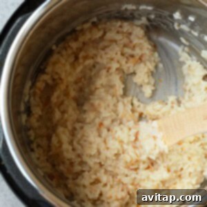 Creamy Instant Pot Coconut Rice 2 An Instant Pot filled with perfectly cooked coconut rice and a wooden spoon, showcasing the fluffy texture.